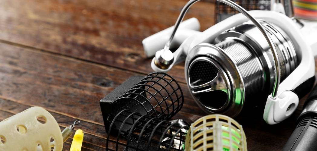 A feeder reel alongside cage and method feeders on a wooden bank stick top